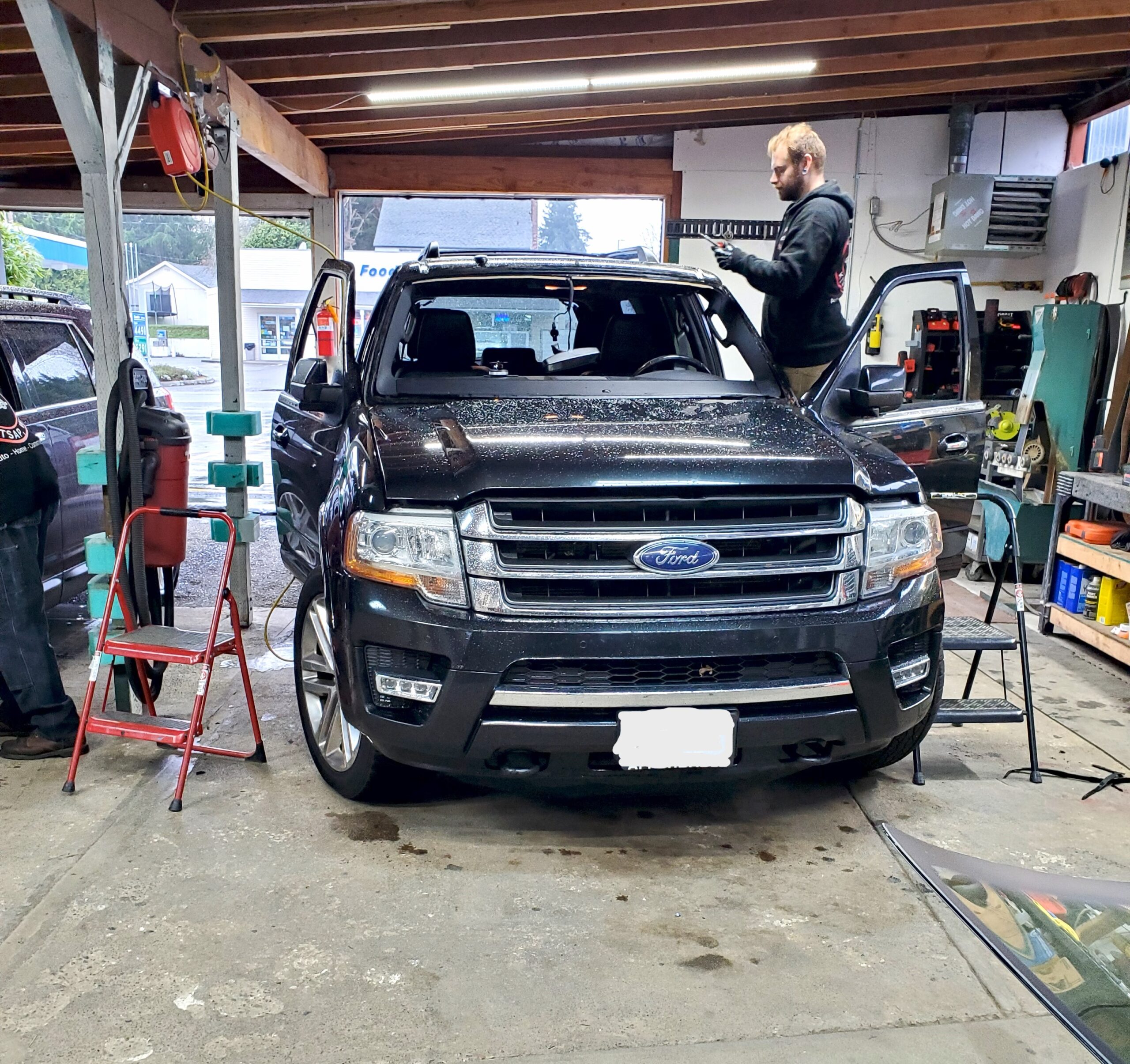 Noah and Paul working on cars in the shop