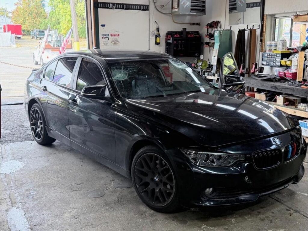 Black BMW with a smashed windshield before windshield replacement in Bremerton