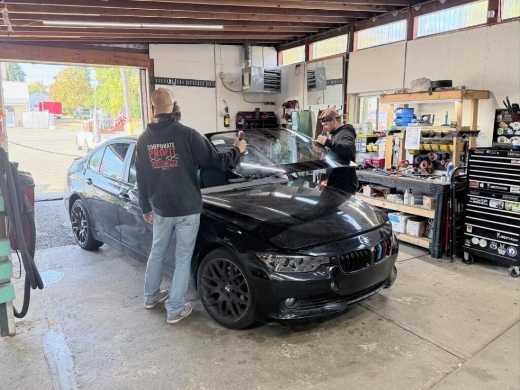 Two valueGLASS technicians setting a new windshield into a BMW in Bremerton, WA